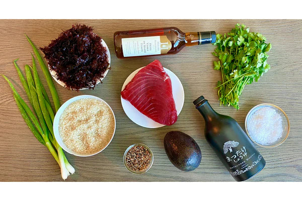 Chef curated ingredients and fresh ahi tuna gathered on a counter ready to prepare for a fresh poke bowl