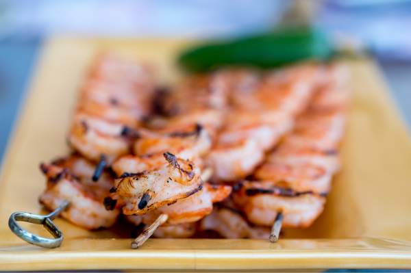 Grilled shrimp skewers on a plate for an Easter meal spread
