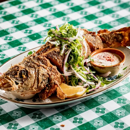 fried whole branzino on picnic table