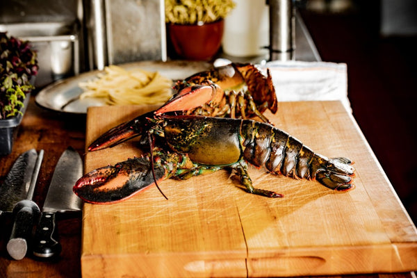 live maine lobster on a cutting block in the kitchen