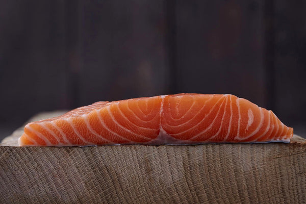 loch duart salmon on a wooden slab